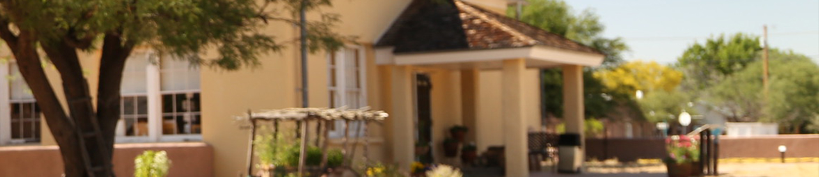 A side view of the covered entrance to the Presidio and a glimpse of the on-site gardens.